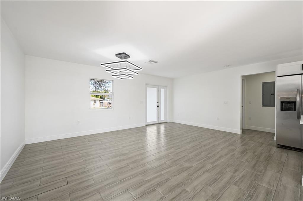 4448 18th Avenue Southwest Naples, FL 34116 - Photo 4 of 40 a view of empty room with wooden floor and window