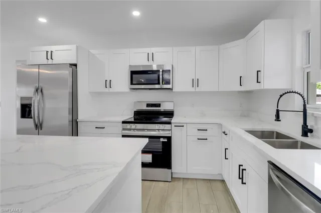 a kitchen with white cabinets and stainless steel appliances
