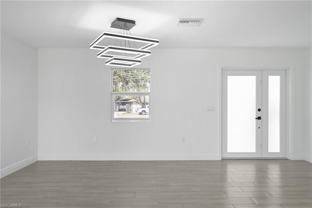 4448 18th Avenue Southwest Naples, FL 34116 - Photo 6 of 40 a view of an empty room with wooden floor and a window