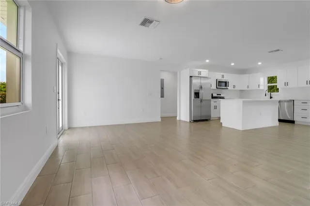 a view of a kitchen with a sink and dishwasher a refrigerator with wooden floor