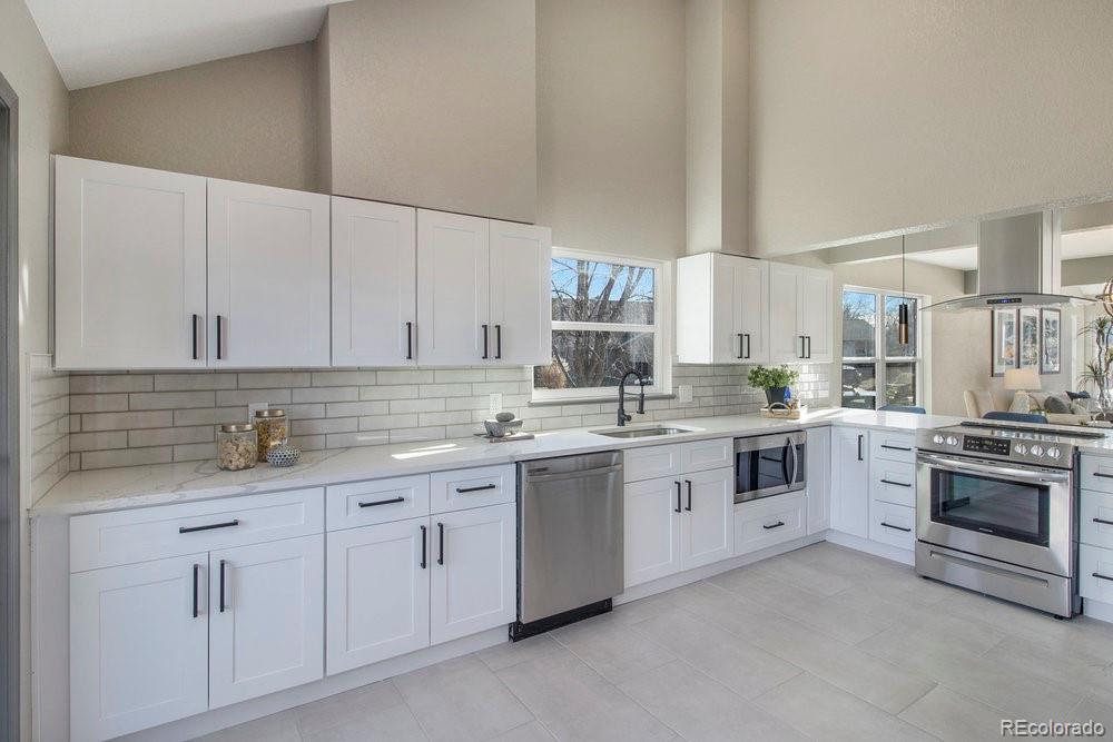 a kitchen with white cabinets sink and stove