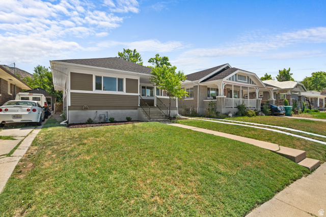 2862 Fowler Avenue Ogden, UT 84403 - Photo 3 of 23 Siding exterior with white trim, a dark shingled roof, and a mature front lawn