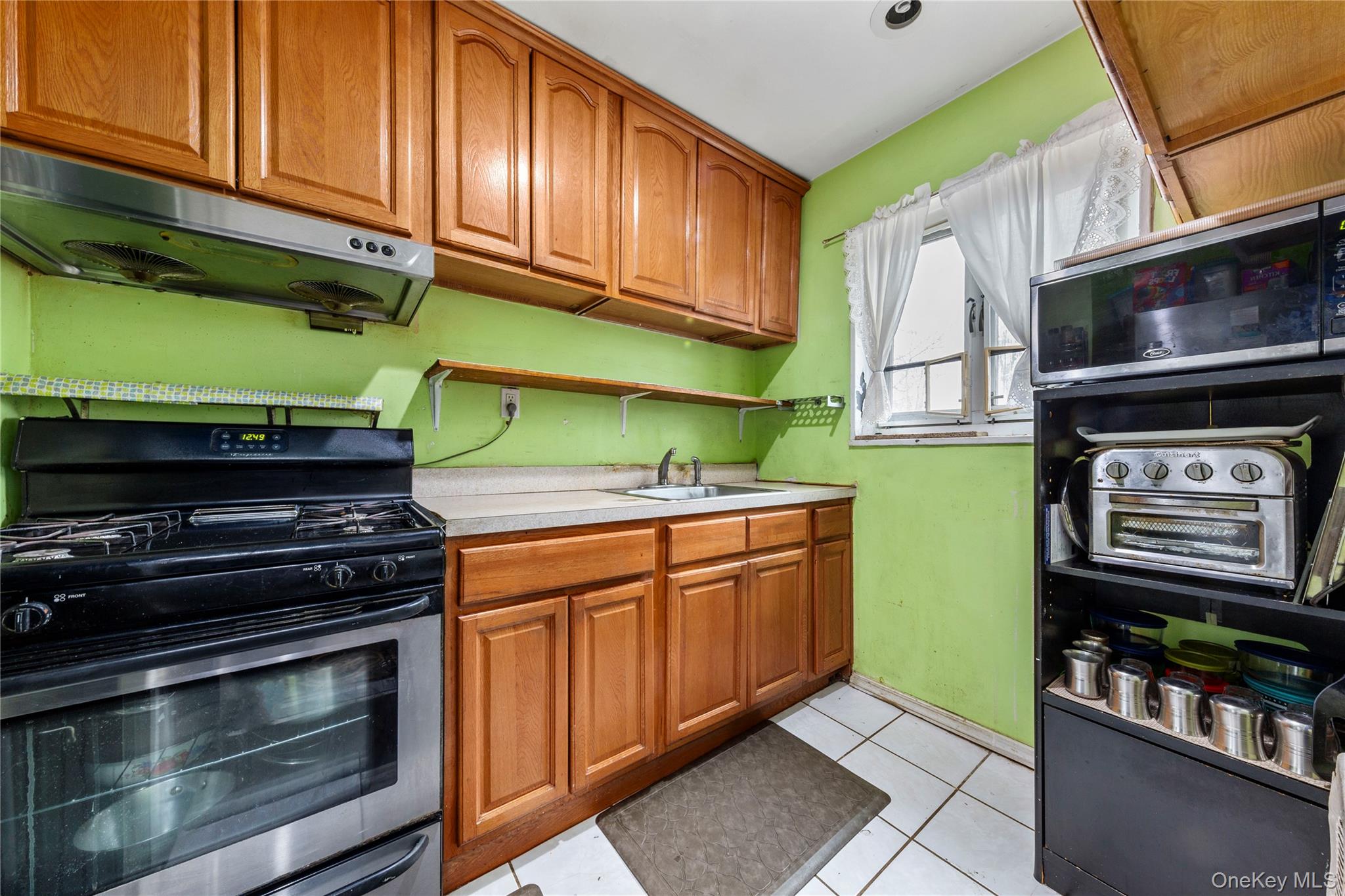 221-15 Manor Road, Unit UPPR Queens, NY 11427 - Photo 13 of 16 a kitchen with stainless steel appliances a stove and a microwave