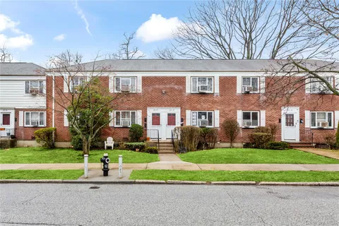 a front view of a house with a yard and plants