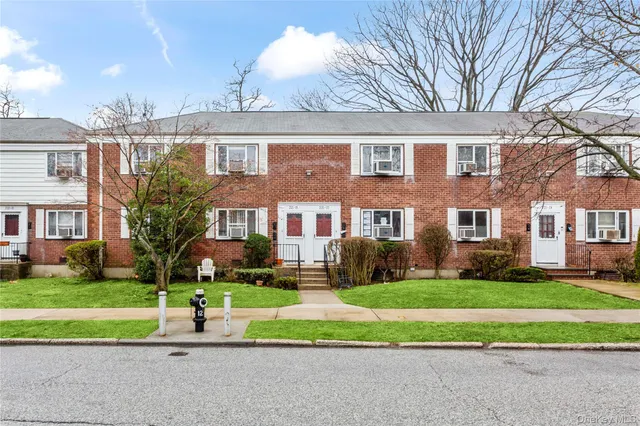 a front view of a house with a yard and plants