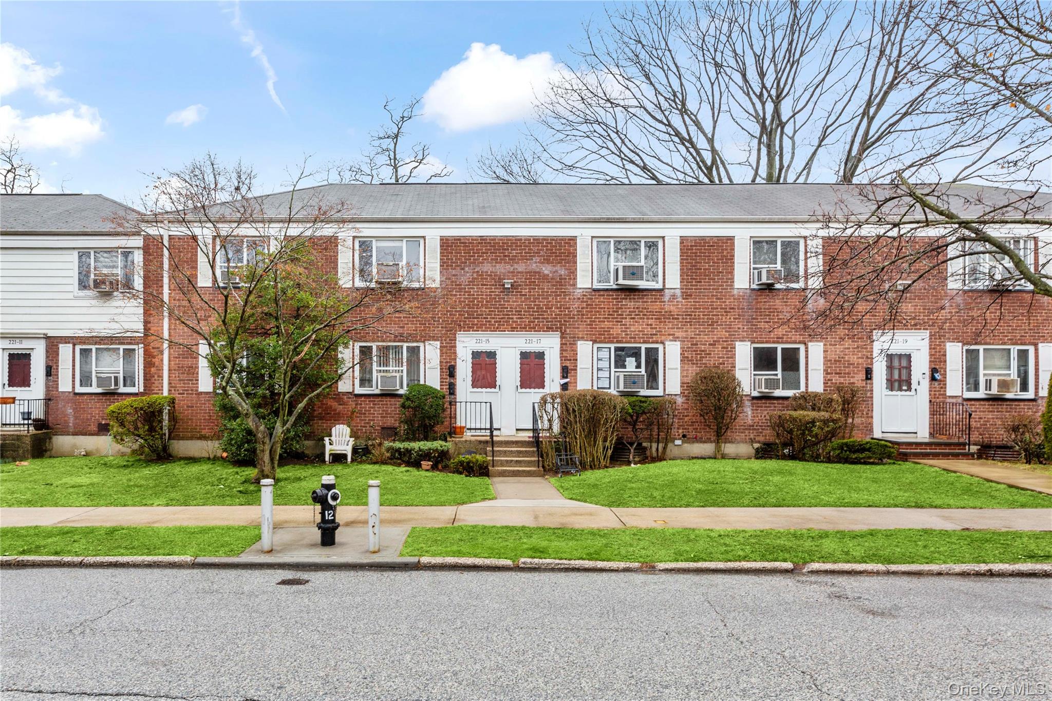 221-15 Manor Road, Unit UPPR Queens, NY 11427 - Photo 3 of 16 a front view of a house with a yard and plants