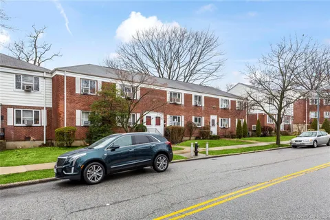 a car parked in front of a white house