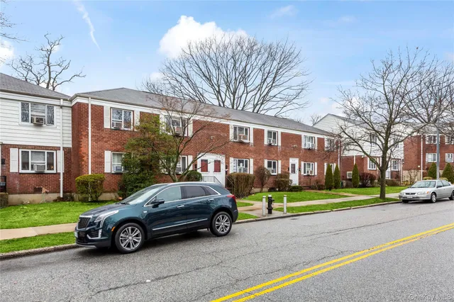 a car parked in front of a white house