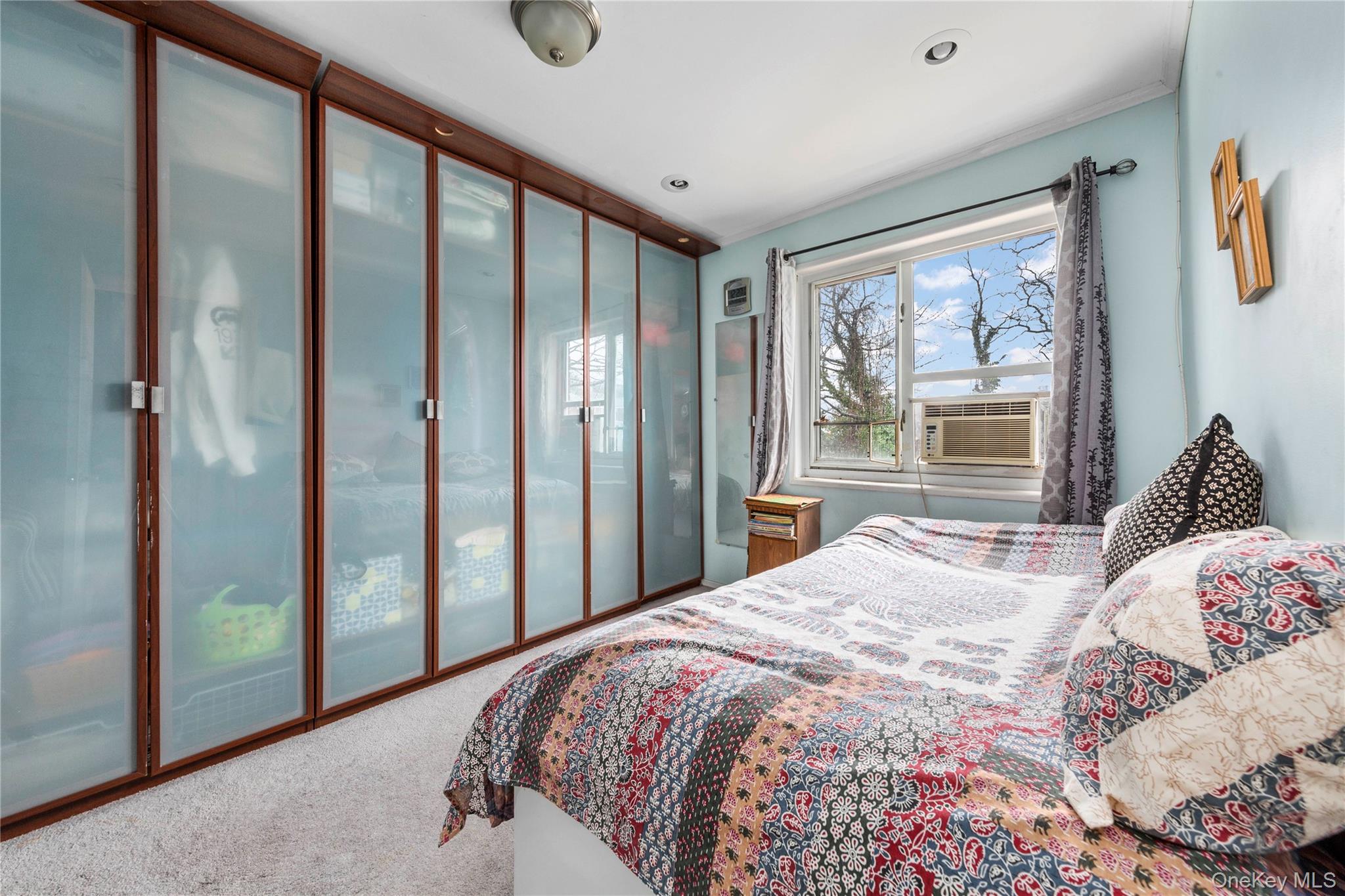 221-15 Manor Road, Unit UPPR Queens, NY 11427 - Photo 9 of 16 a bedroom with a large bed and a large window