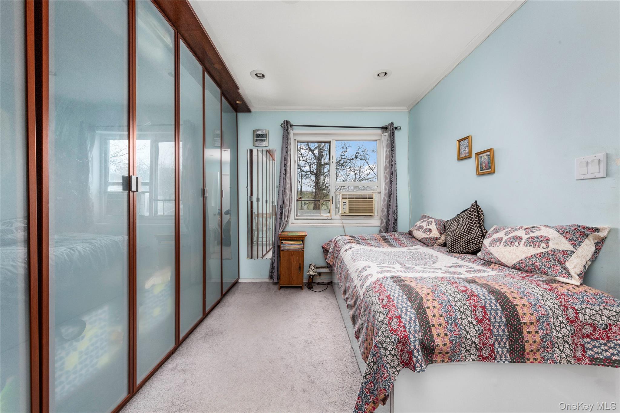 221-15 Manor Road, Unit UPPR Queens, NY 11427 - Photo 10 of 16 a bedroom with a bed couch and a window