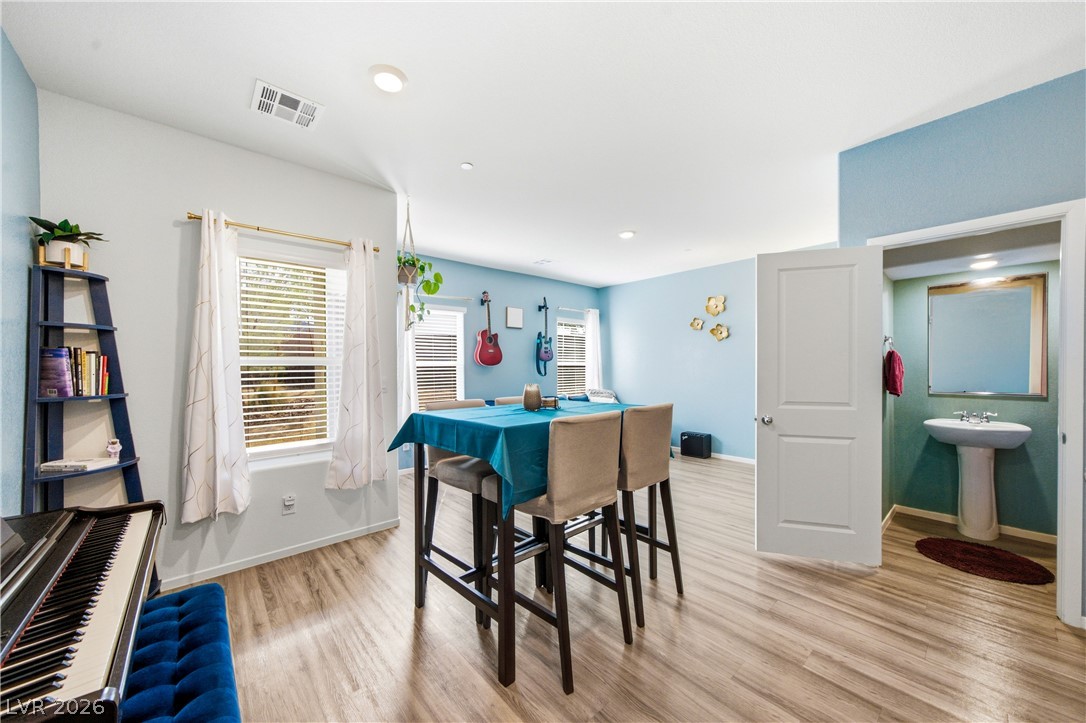 495 Blue Ridge Cove Henderson, NV 89002 - Photo 7 of 32 A versatile open-concept space features resilient wood flooring and bright natural light, ideal for both entertaining and relaxation.