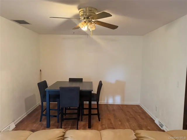 a view of a dining room with furniture and a chandelier fan