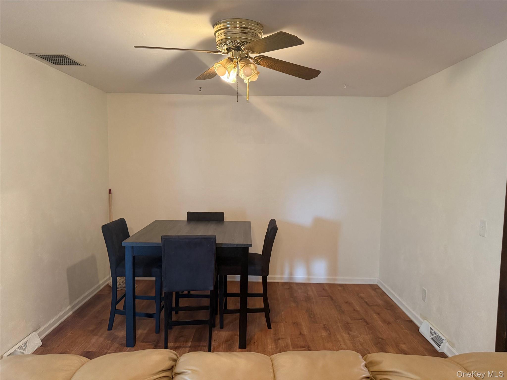 a view of a dining room with furniture and a chandelier fan