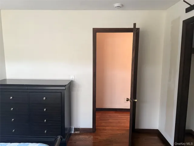 an empty room with wooden floor and closet