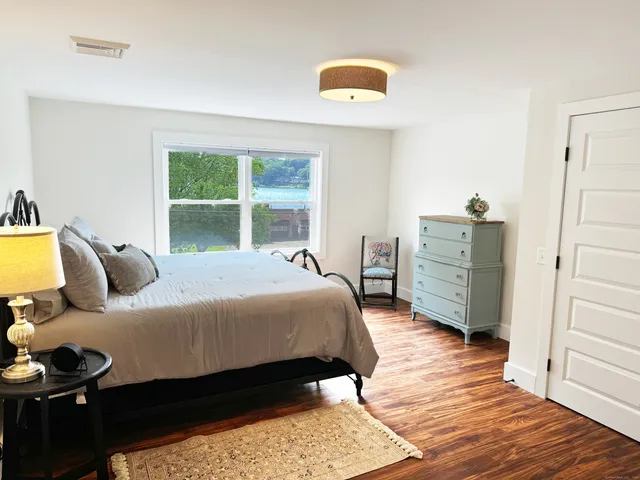 a bedroom with a bed and wooden floor