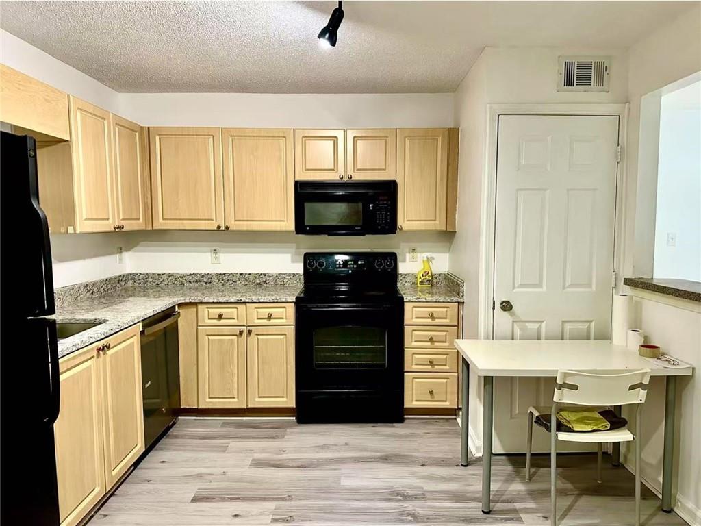 3665 Chestnut Drive, Unit F2 Atlanta, GA 30340 - Photo 20 of 21 a kitchen with granite countertop a stove top oven a sink and a refrigerator