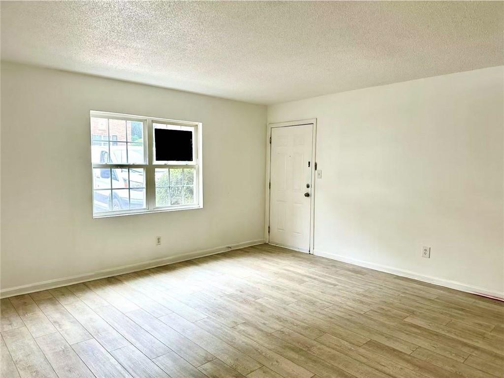 3665 Chestnut Drive, Unit F2 Atlanta, GA 30340 - Photo 6 of 21 an empty room with wooden floor and windows