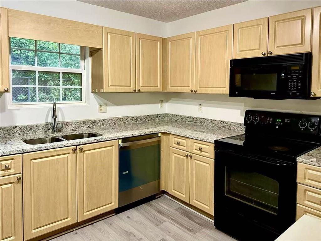 3665 Chestnut Drive, Unit F2 Atlanta, GA 30340 - Photo 8 of 21 a kitchen with granite countertop white cabinets appliances and a window
