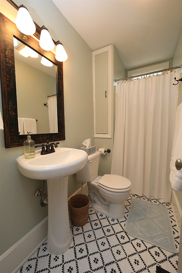 1530 Carson Street Raleigh, NC 27608 - Photo 9 of 21 The hall bathroom includes a pedestal sink, newly painted tile floors, stained glass window and shower. Hall Bathroom