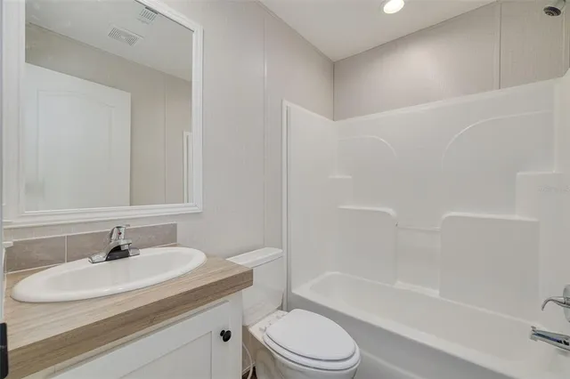 a bathroom with a sink toilet vanity and shower