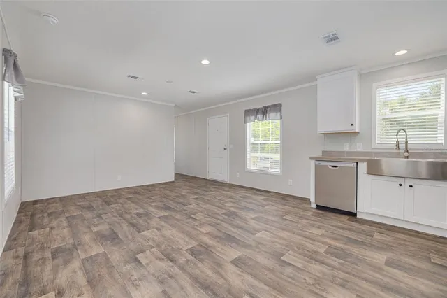 a view of a kitchen with a sink dishwasher and wooden floor
