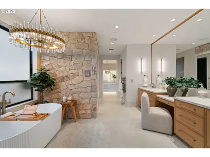 a bathroom with a sink vanity granite tub and a mirror
