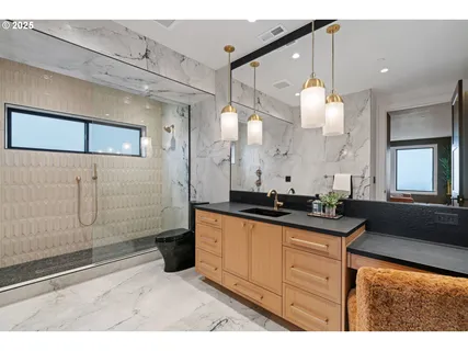 a bathroom with a granite countertop sink a large mirror and a shower