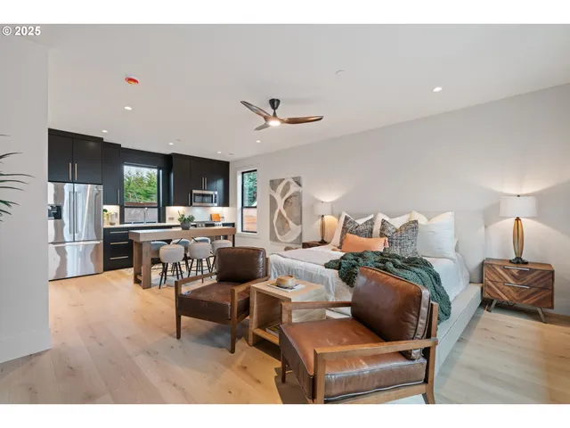 a living room with couches a flat screen tv and a floor to ceiling window