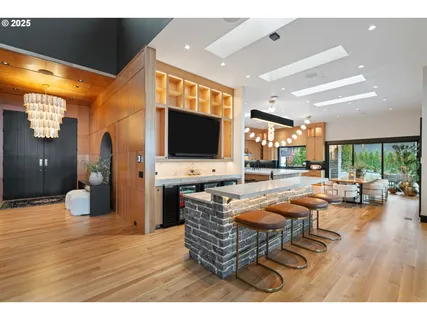 a living room with furniture a flat screen tv and floor to ceiling window