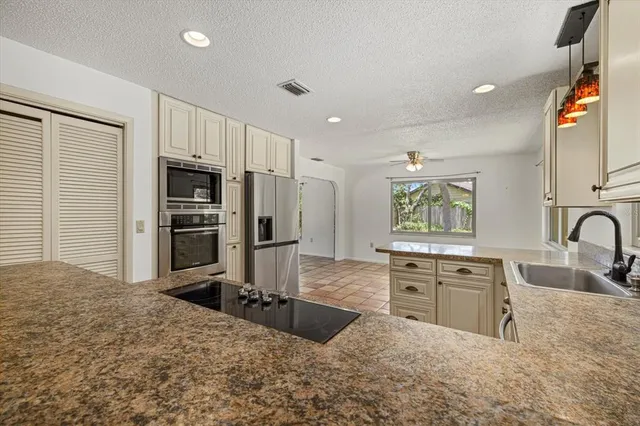 a large kitchen with kitchen island a sink stainless steel appliances and cabinets
