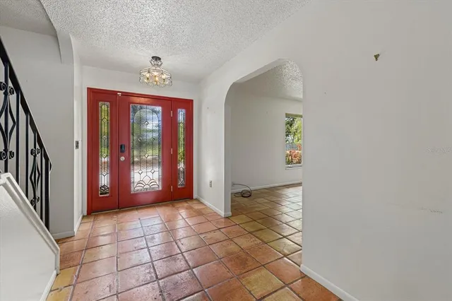 a view of a hallway with windows and chandelier