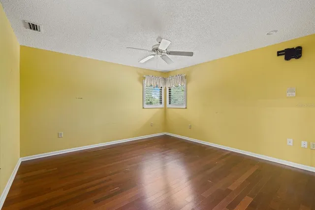 a view of a room with wooden floor and ceiling fan