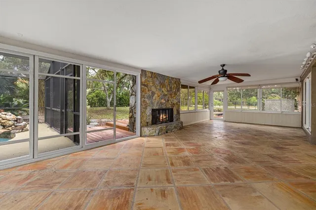 a view of an empty room with wooden floor and a fireplace