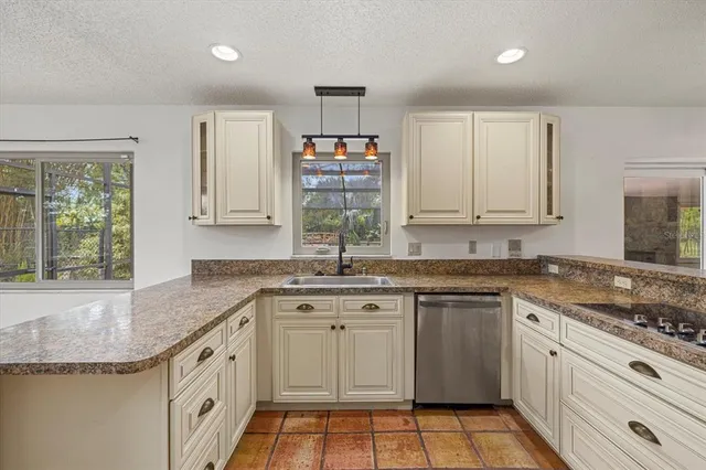 a kitchen with granite countertop a sink stainless steel appliances and cabinets