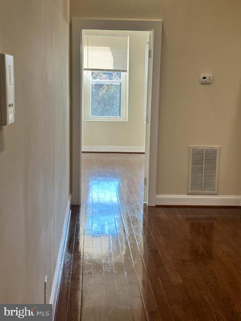 2740 St Paul Street, Unit 3 Baltimore, MD 21218 - Photo 3 of 6 a view of an empty room with wooden floor and a window