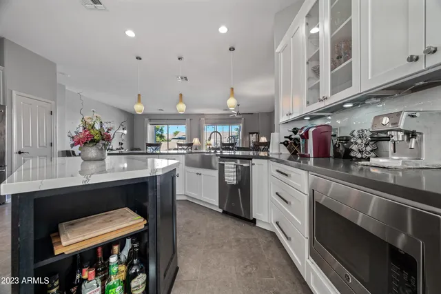 a kitchen with a sink dishwasher and white cabinets with wooden floor
