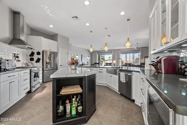 a kitchen with kitchen island granite countertop a sink cabinets and stainless steel appliances