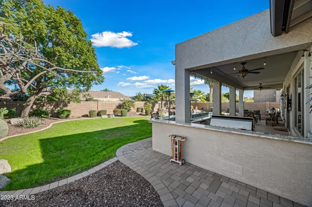 a view of a patio with a table and chairs under an umbrella with a fire pit