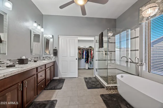 a bathroom with a double vanity sink a toilet a mirror and shower
