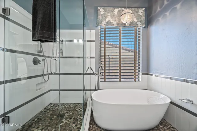 a bathroom with a white bathtub and window