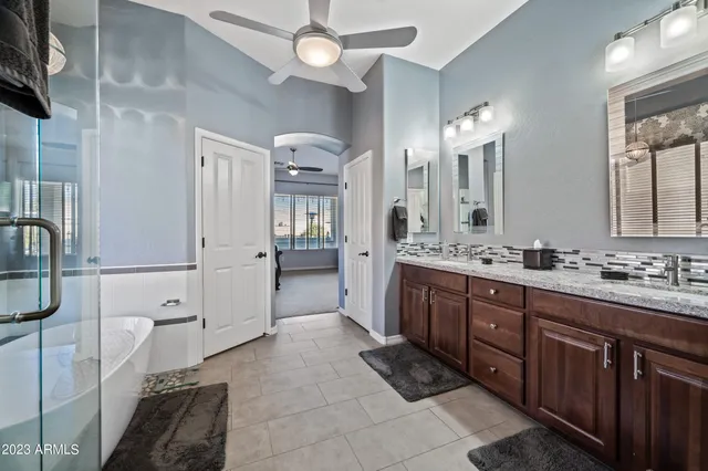 a spacious bathroom with a double vanity sink a mirror and a shower
