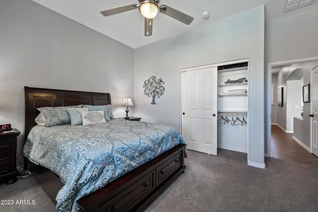a spacious bedroom with a bed and a chandelier