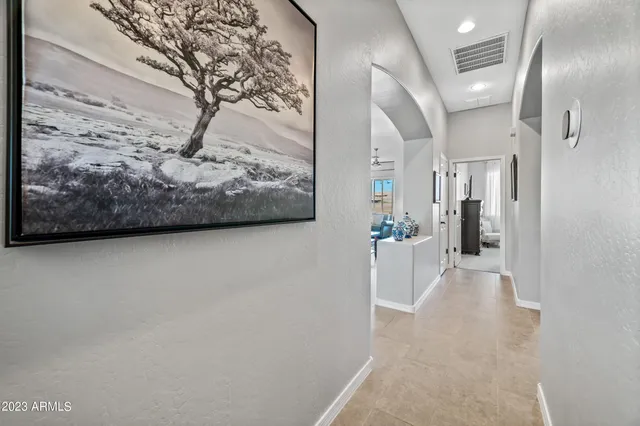 a view of a hallway with wooden floor and a large mirror
