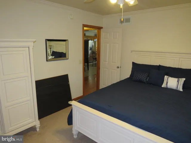 a bed sitting in a bedroom next to a window and a wooden floor