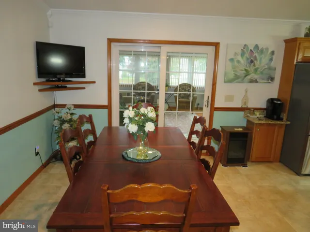 a view of a dining room with furniture and a flat screen tv