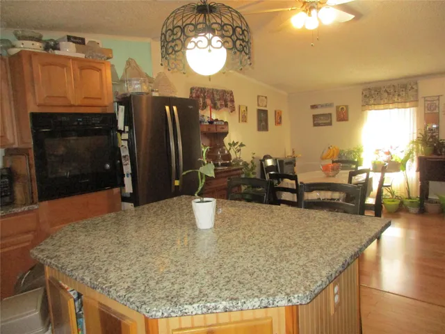 a kitchen with granite countertop a refrigerator a stove a oven a dining table and chairs