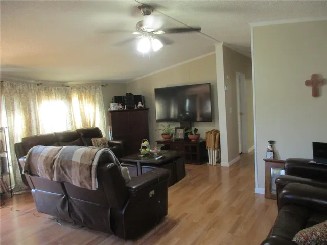 a living room with furniture a flat screen tv and a window