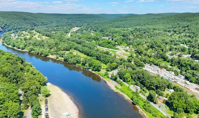 an aerial view of a houses with a yard and lake view
