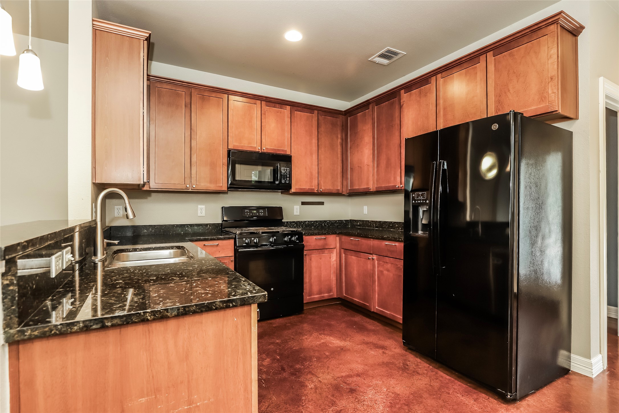 1701 Sanchez Street, Unit A Austin, TX 78702 - Photo 9 of 19 Black appliances and granite countertops create a striking contrast in this well-appointed kitchen.