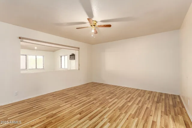 a view of a room with wooden floor and ceiling fan